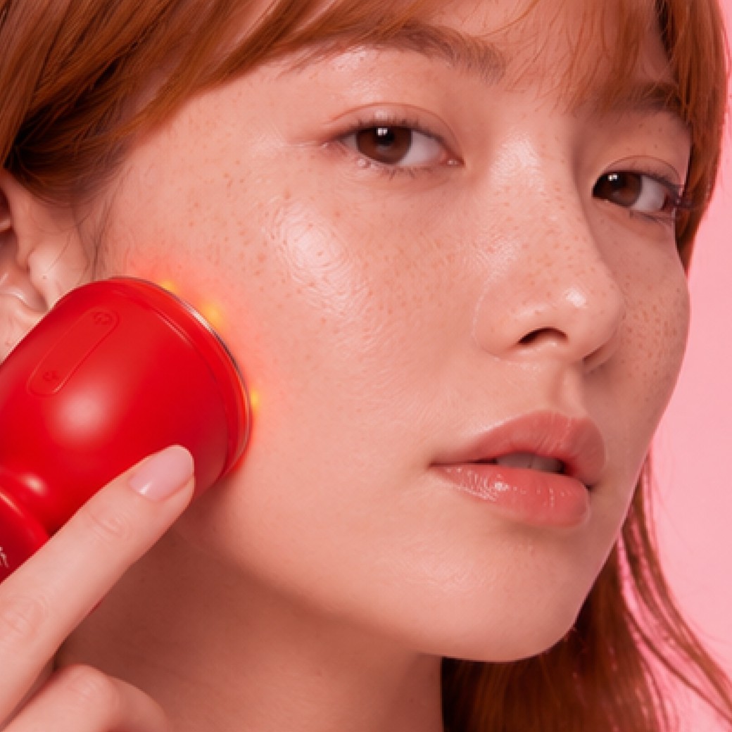 Femme utilisant l'appareil EMSkin Pro sur la joue