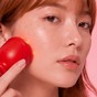 Femme utilisant l'appareil EMSkin Pro sur la joue